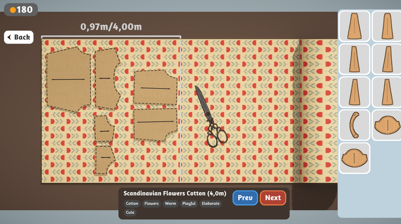 Dressmaker game cutting screen with paper pattern pieces arranged across patterned fabric